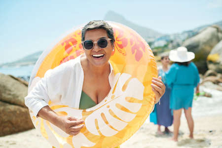Not even the 20 year olds have this fun energy. a mature woman standing and holding a pool...