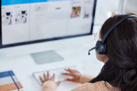 My workload just increased and I dont mind. an unrecognizable call center worker at their desk in...