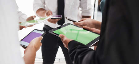 Linking up to get more done. Closeup shot of a group of unrecognisable businesspeople using digital...