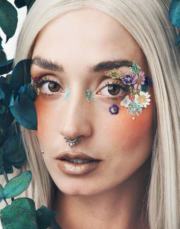 Adorned with natural beauty. Cropped portrait of an attractive young woman posing against a grey...