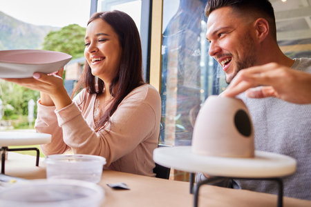 Art is something were both passionate about. a young couple painting ceramics in an art studio.の写真素材