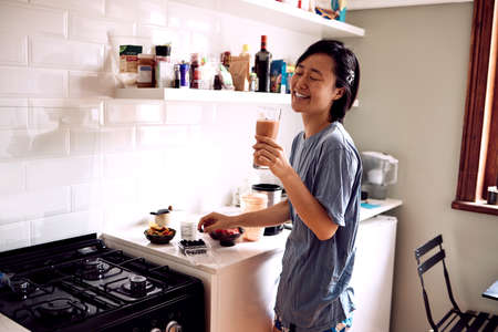 This must be the best smoothie Ive ever made. a young woman enjoying a homemade smoothie in her kitchen at home.の写真素材