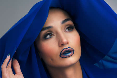 Shes got a lot to think about. Studio shot of a beautiful young woman looking thoughtful while posing against a grey background.の写真素材