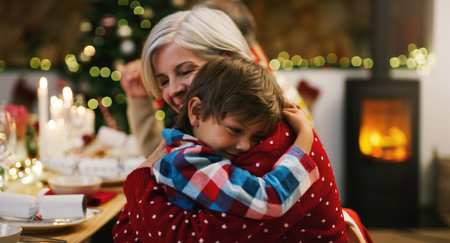 My favourite Christmas gift calls me grandma. an affectionate senior woman hugging her grandson during a Christmas dinner party at home.の写真素材