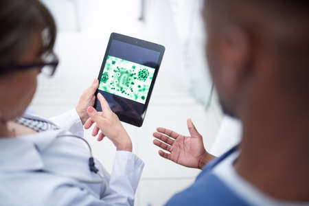 Healthy bacteria are present in your immune system. a doctor looking at a tablet.