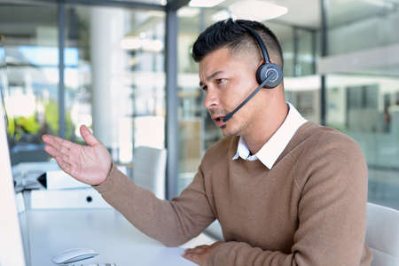 Let me run through the options for you... a young call centre agent working in an office.の写真素材