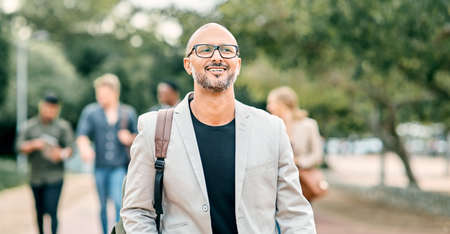 Creativity is intelligence having fun. a confident mature businessman walking through the city with...