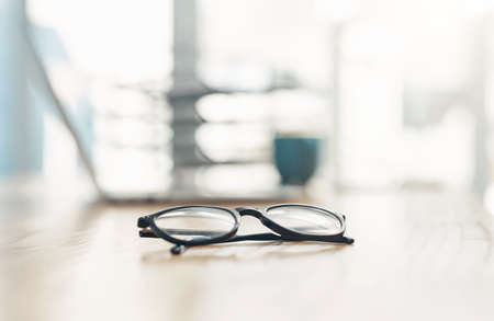 What is it that you visualise for yourself. Closeup shot of spectacles on a table in an office.の写真素材