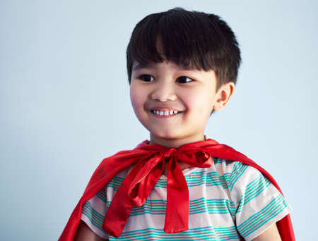 The innocent smile of a child brings so much happiness. an adorable little boy pretending to be a superhero while playing at home.の写真素材
