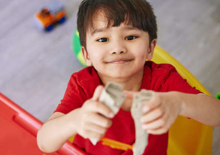 Little boys are a ton of fun. Portrait of an adorable little boy playing with toys at home.の写真素材