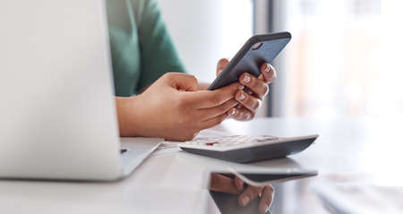 Budgeting is a breeze with all the right tools. an unrecognisable woman using a smartphone and...