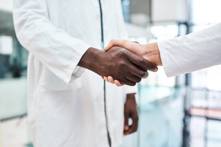 Improving clinical performance through teamwork. Closeup shot of two doctors shaking hands in a hospital.の写真素材
