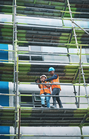 There are many facets to the construction sector. a young man and woman using a digital tablet while...