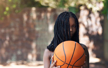 Guess the balls in my court. Cropped portrait of an attractive young female athlete standing on the basketball court.の写真素材