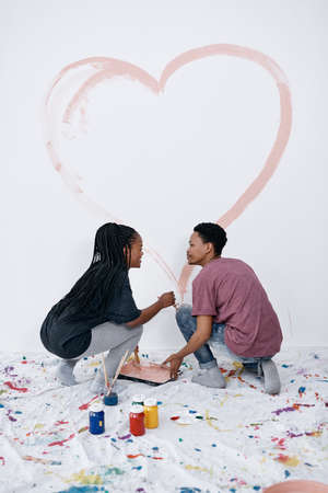 Art is love and love is art. a young couple painting a heart on a wall.の写真素材