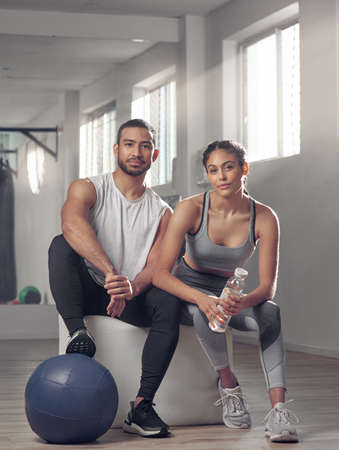 Were got 99 problems and laziness aint one. two young athletes sitting together at the gym.の写真素材