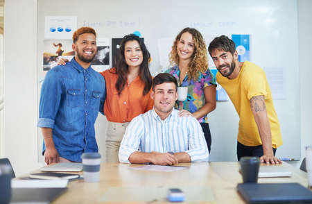Were not afraid to step up to the business plate. Portrait of a group of young businesspeople having a meeting in a modern office.の写真素材
