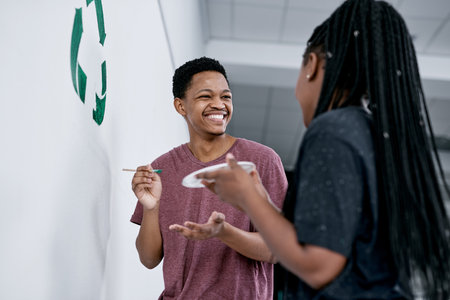 Making home green friendly zone. a young couple painting a recycle symbol on a wall.の写真素材