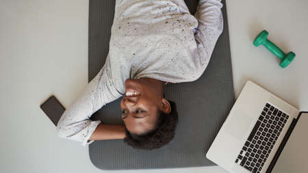 Be active, be healthy, be happy. High angle shot of a young woman lying on an exercise mat with a...
