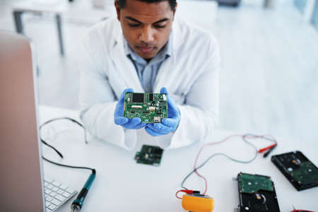 They dont call him the pro for nothing. a young man repairing computer hardware in a laboratory.の写真素材