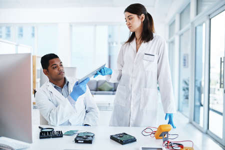 The best in the computer repair business. a young man and woman repairing computer hardware in a...