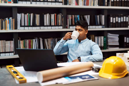 Time to build a dream but first coffee. a young architect having a coffee break while working in a modern office.の写真素材