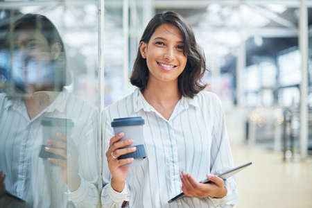 A small device that holds a huge business network. a young businesswoman using a digital tablet in a...