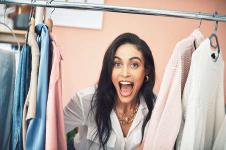 Today Im letting my followers into my wardrobe. a young woman sticking her head in between items on...