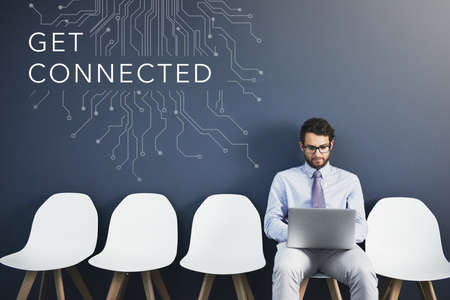 Business man with digital connection and internet service while sitting and typing on a laptop. Young caucasian male entrepreneur or programmer connected to an online web or websiteの写真素材