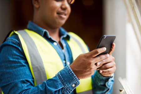 If I cant do it, someone in my contacts will. a engineer using his cellphone while at work.
