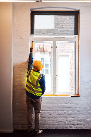 Well have to replace this window. a engineer taking measurements on a construction site.の写真素材