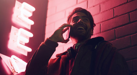 Im waiting for you at the spot. a young man talking on his cellphone while standing outside a...