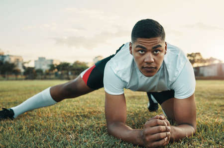 His goal is to become of the greatest rugby players. Full length shot of a handsome young rugby player training on the field during the day.の写真素材