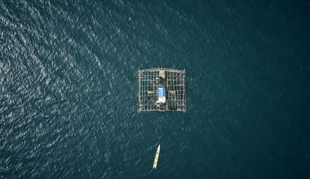 Living close to the fish makes them an easy catch. High angle shot of a built fishing structure floating in the middle of the ocean called a kelong.の写真素材