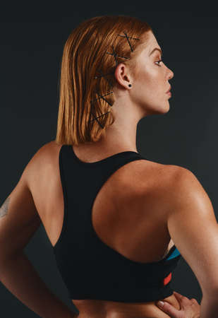Her perfect form is one to admire. Studio shot of a sporty young woman posing against a black background.の写真素材