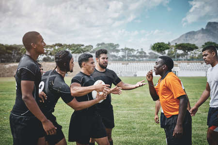 Dont argue. a group of young rugby players receiving a penalty during a match on a rugby field.の写真素材
