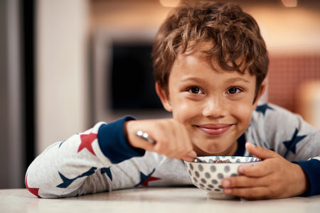 Breakfast is the happiest meal of the day. a young boy eating cereal at home.の写真素材