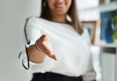 Id love to partner with you. Closeup shot of an unrecognisable extending a handshake in an office.の写真素材