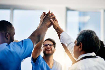 Doctors celebrating medical success after working together as a team and give each other motivating...