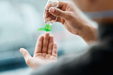 Washing your hands makes the world of difference. a businessman using hand sanitiser to disinfect...