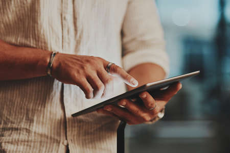 Staying connected to ensure the best results. Closeup shot of an unrecognisable businessman using a...