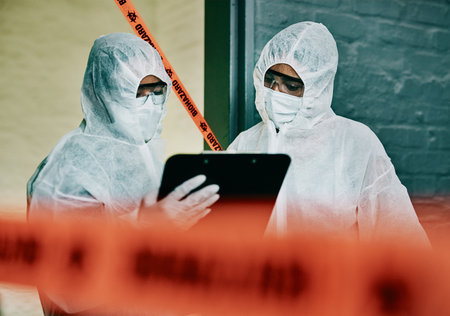 Covid, corona virus and outbreak healthcare workers inspecting contamination on site with red tape, protective mask and clipboard. Medical doctor or scientist working together during pandemic crisisの写真素材