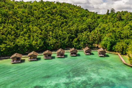 If youre looking to get away, this is the place. High angle shot of the overwater bungalows along the coast of the Raja Ampat Islands in Indonesia.の写真素材