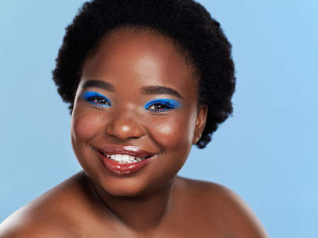 A positive mindset makes life more beautiful. Studio shot of a beautiful young woman posing against a blue background.の写真素材