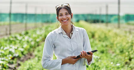 Shes an expert in this field. Portrait of an attractive young scientist using a digital tablet while studying plants and crops outdoors on a farm.の写真素材