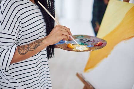 Give shape and color to whats on your mind. an unrecognizable woman holding a painters palette.の写真素材