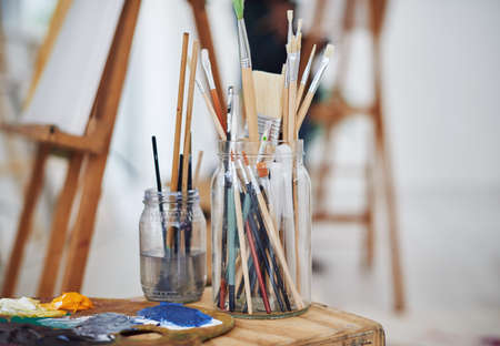 Let the brush guide you. Still life shot of paintbrushes in jars in a art studio.の写真素材