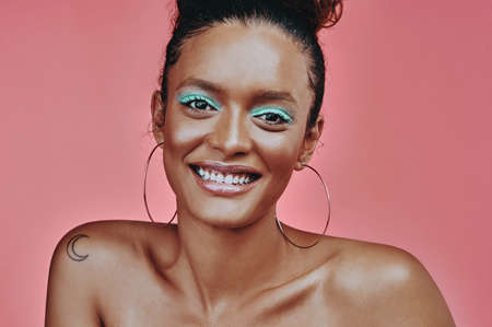 You can do so much to make your brown eyes pop. a beautiful young woman wearing makeup while posing against a pink background.の写真素材