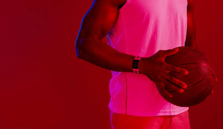 Keep practicing until you get it right. Red filtered shot of an unrecognizable sportsman posing with a basketball in the studio.の写真素材