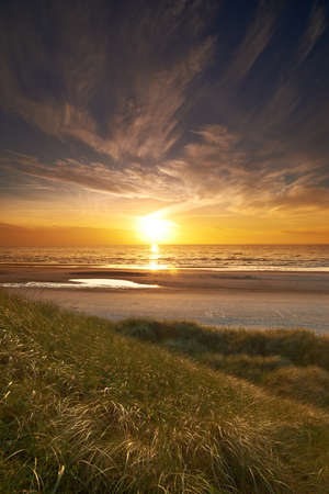 Sunset by the beach. A photo of sunset at the coastline of Jutland, Denmark.の写真素材